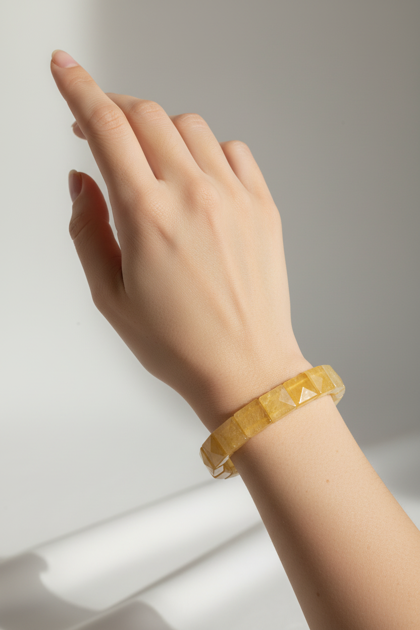 Hand wearing yellow crystal bracelet vertical