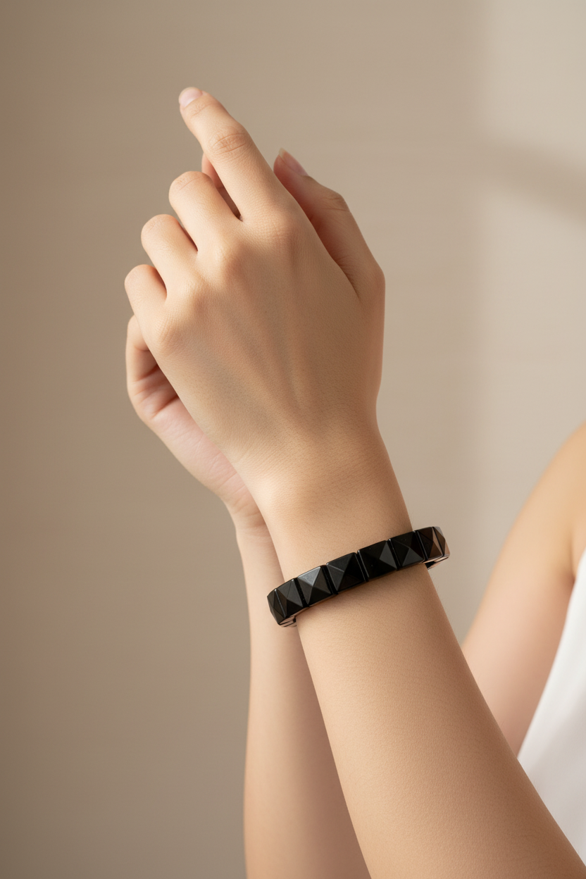 Hand wearing black crystal bracelet vertical